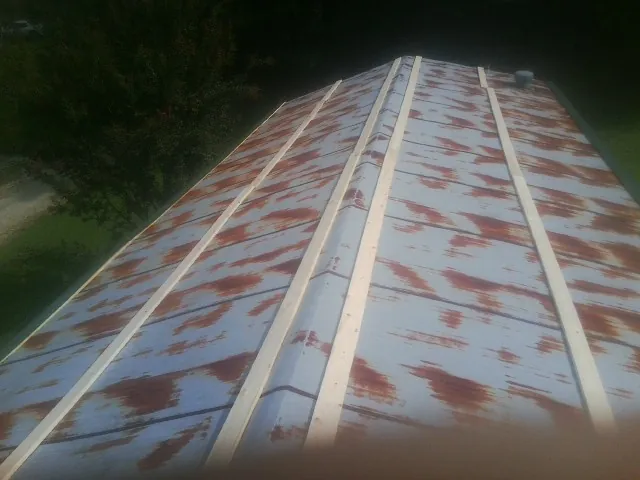 Rusted metal roof panels with new wood purlins before replacement — Storm Damage Roof Repair in Weare by Roofing Brothers