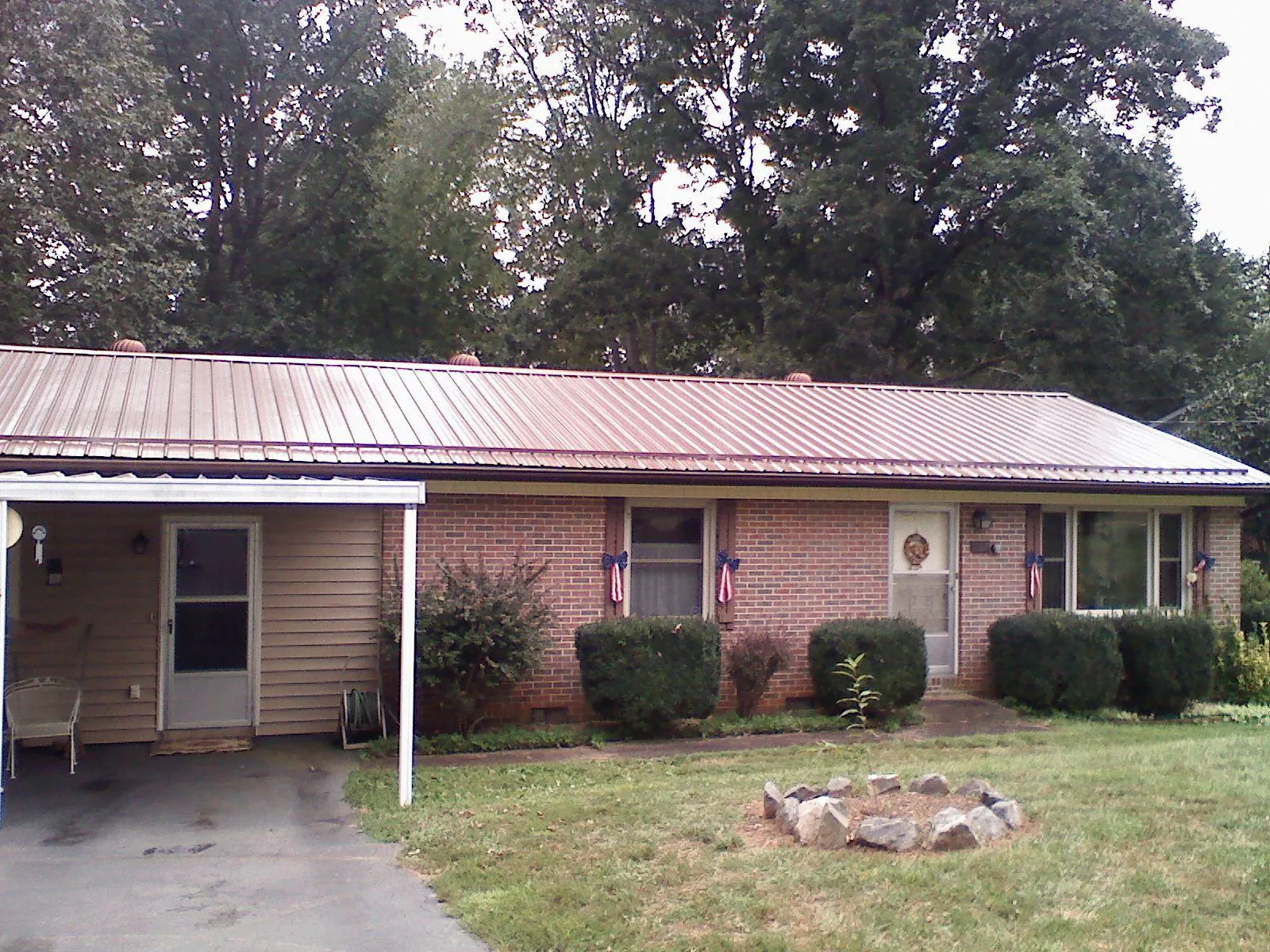 Bronze metal roof and carport on a brick ranch home — Roof Repair work by our crew in Weare